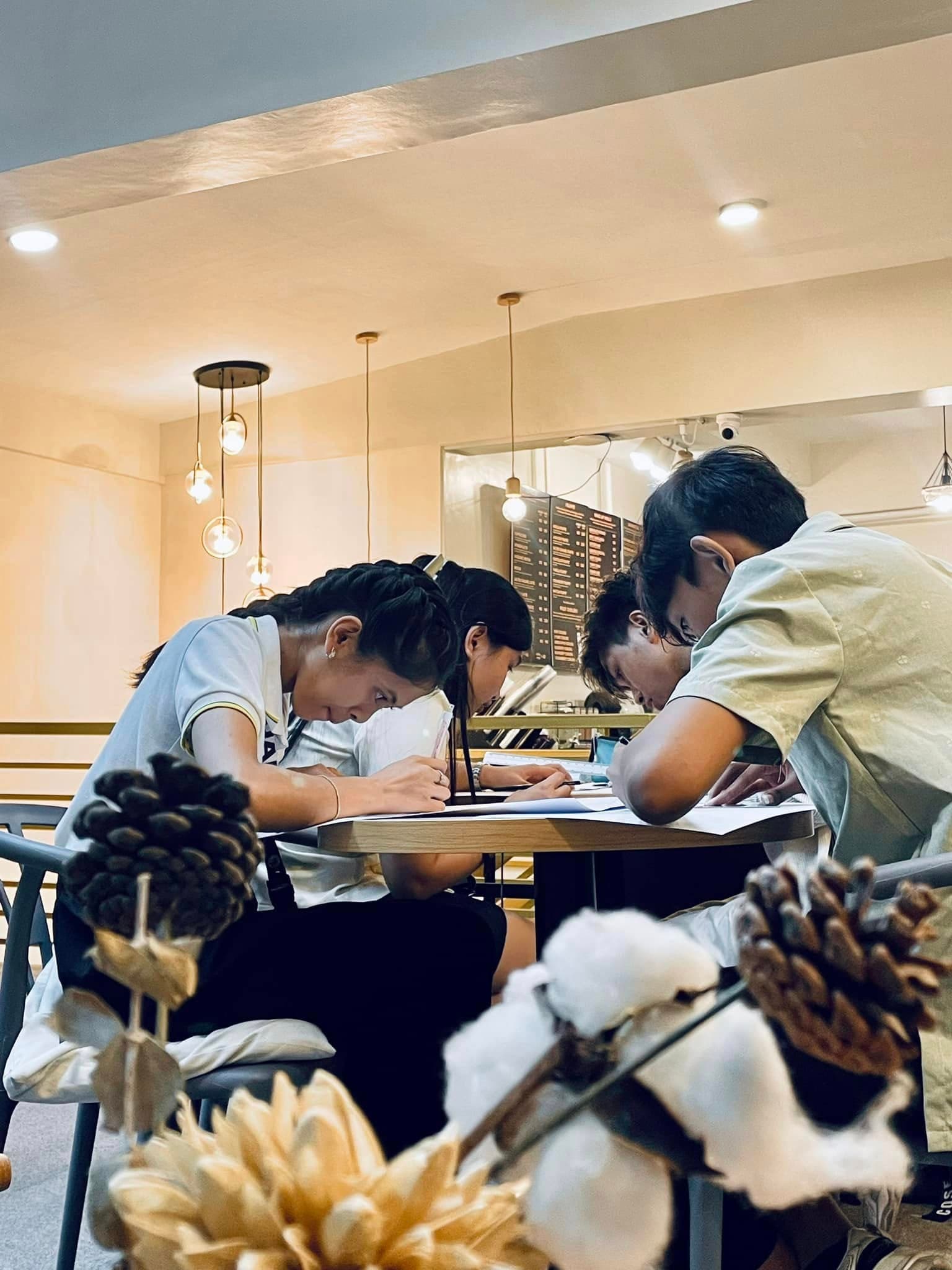 Students focused on group study under pendant lights